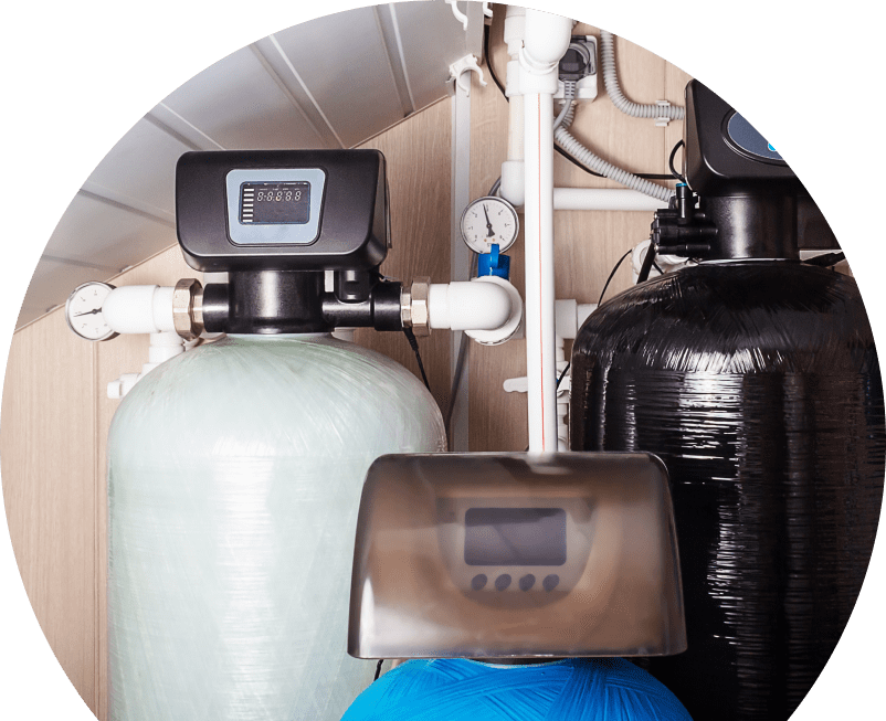 Oosterveld home water filtration system featuring resin tanks, digital control heads, pressure gauges, and connected piping in a utility room. Oosterveld home water filtration system featuring resin tanks, digital control heads, pressure gauges, and connected piping in a utility room.