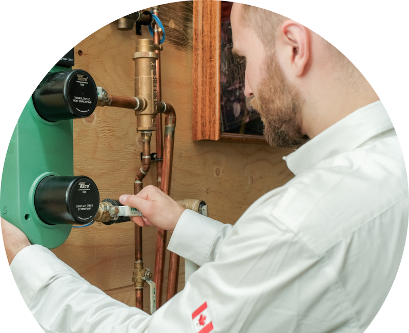 Oosterveld HVAC specialist performing boiler installation, securing a valve on a new hydronic heating system with copper piping and a green circulation pump mounted on a wooden wall. Oosterveld HVAC specialist performing boiler installation, securing a valve on a new hydronic heating system with copper piping and a green circulation pump mounted on a wooden wall.