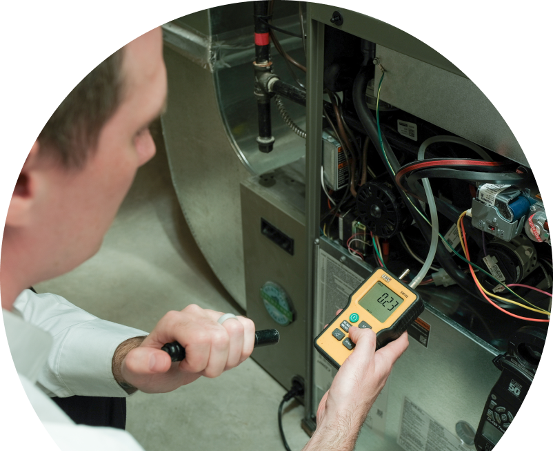 Oosterveld HVAC specialist performing furnace repair on a heating system, using a digital manometer to check pressure. Oosterveld HVAC specialist performing furnace repair on a heating sy