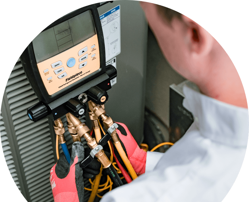A Oosterveld home service crew member uses a digital manifold gauge to check refrigerant levels on an HVAC unit for service. A Oosterveld home service crew member uses a digital manifold gauge to check refrigerant levels on an HVAC unit for service.