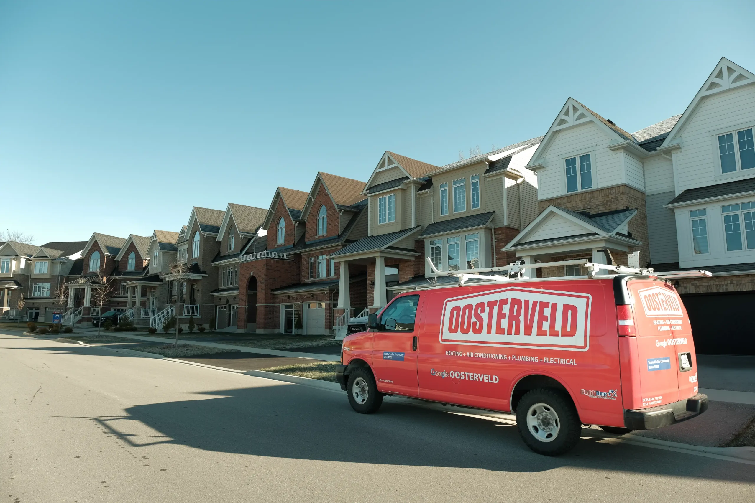 Oosterveld Heating & Air Conditioning service van parked on a Guelph street, ready for fall HVAC tune-ups and maintenance visits.