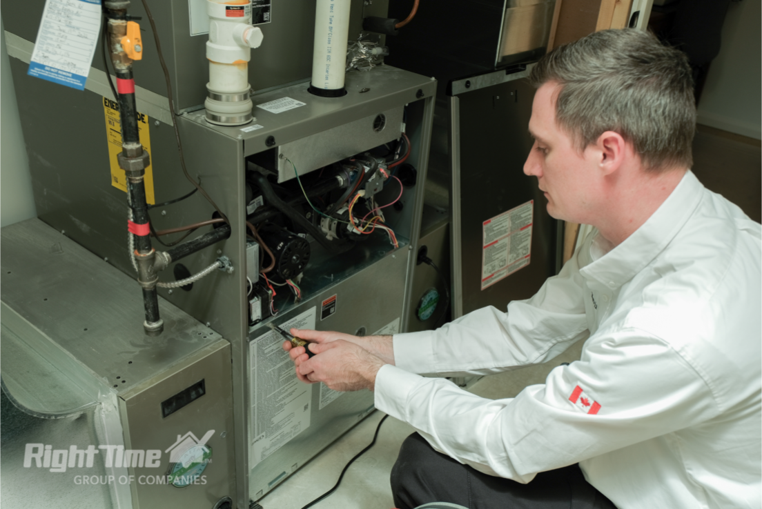 HVAC technician inspecting rust on old furnace components during maintenance visit in Guelph home, checking for replacement needs